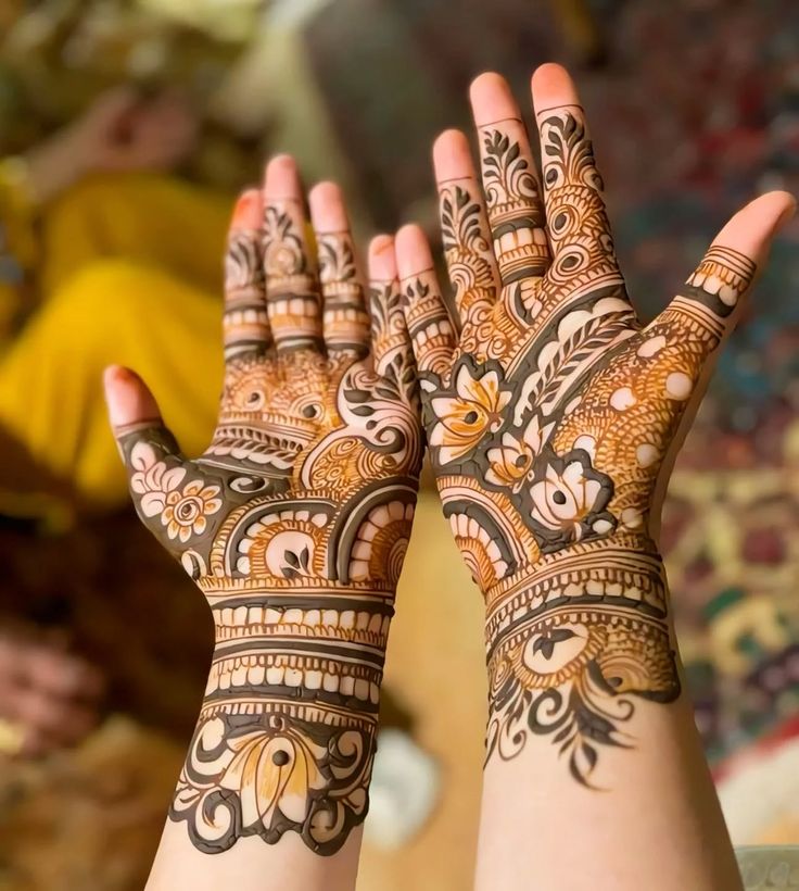 Personalised engagement mehndi design for bride featuring couple silhouettes and mandala.